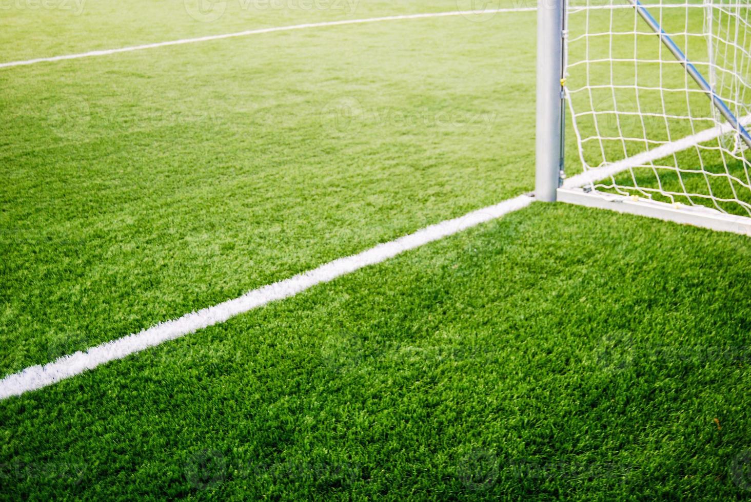 Corner of goalposts on green grass of soccer field, no people photo