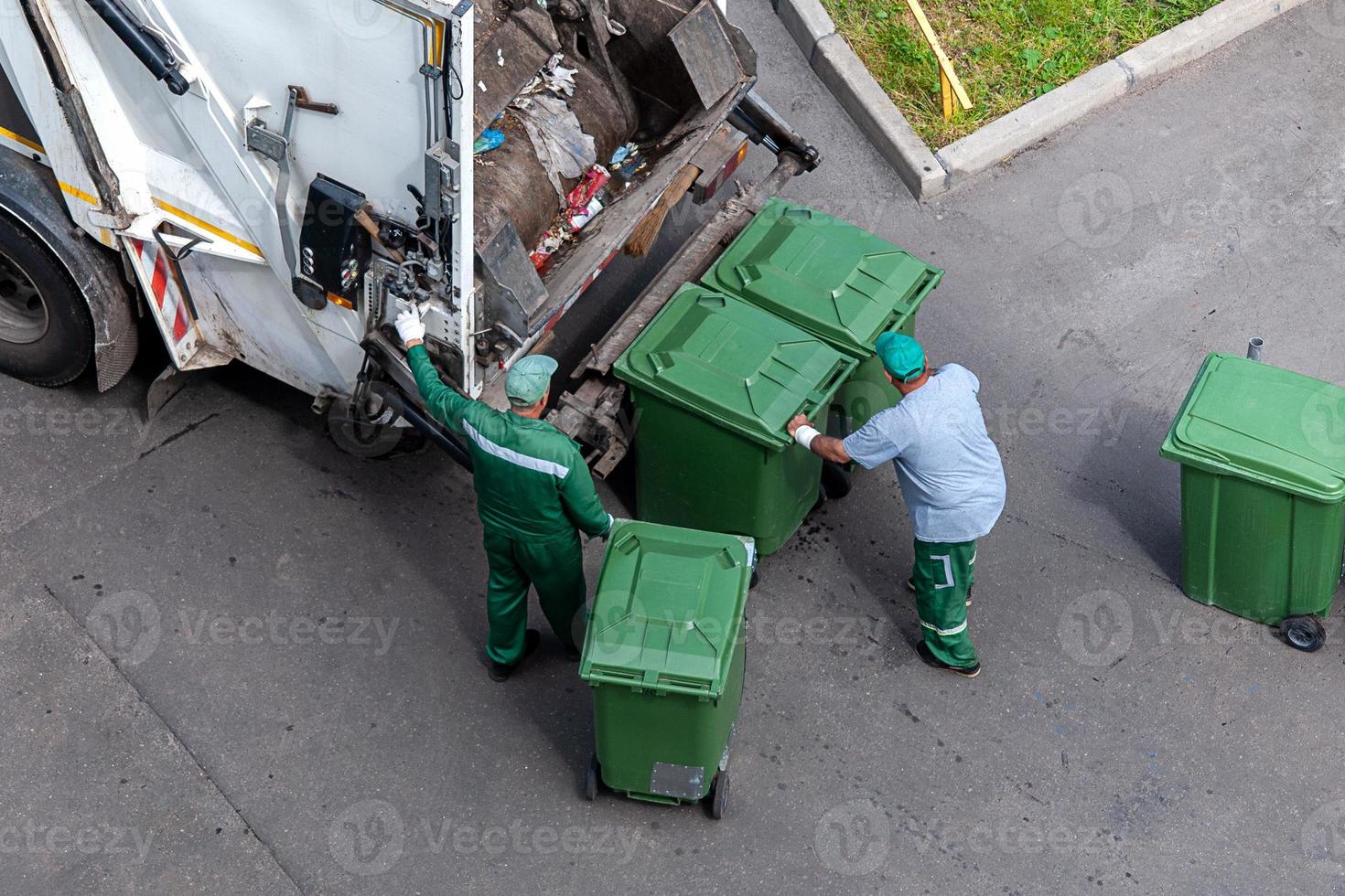 garbage men loading household rubbish in garbage truck, view from above photo