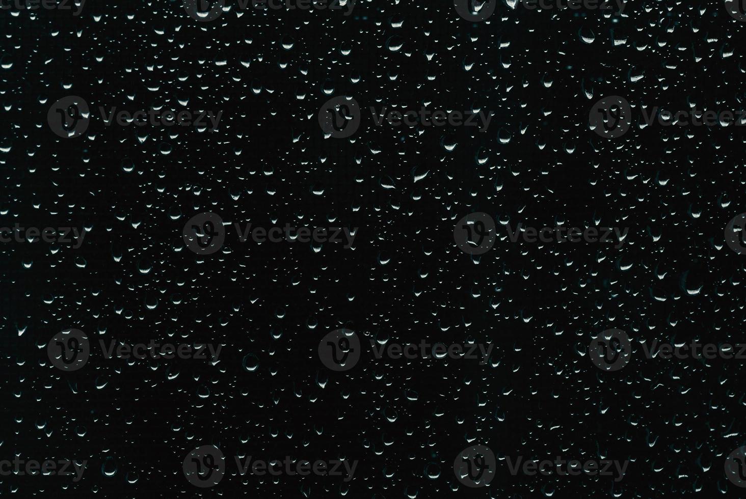Raindrops on black window glass as background photo