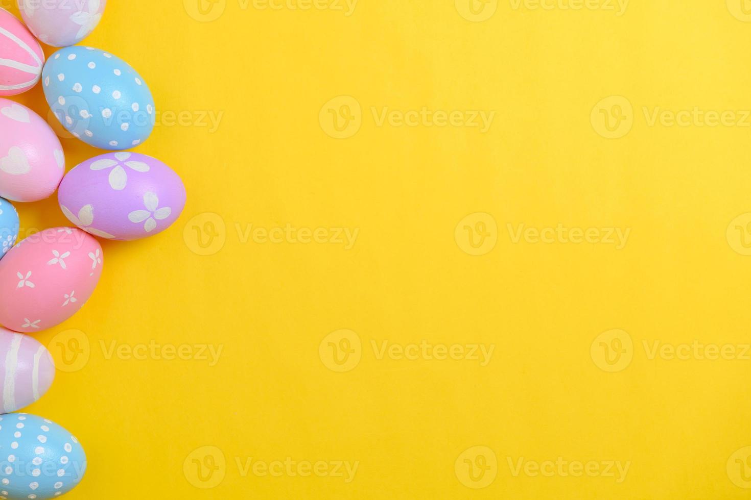 Happy easter holiday celebration concept. Group of painted colourful eggs decoration on a yellow background. Seasonal religion tradition design. Top view, flat lay, copy space. photo