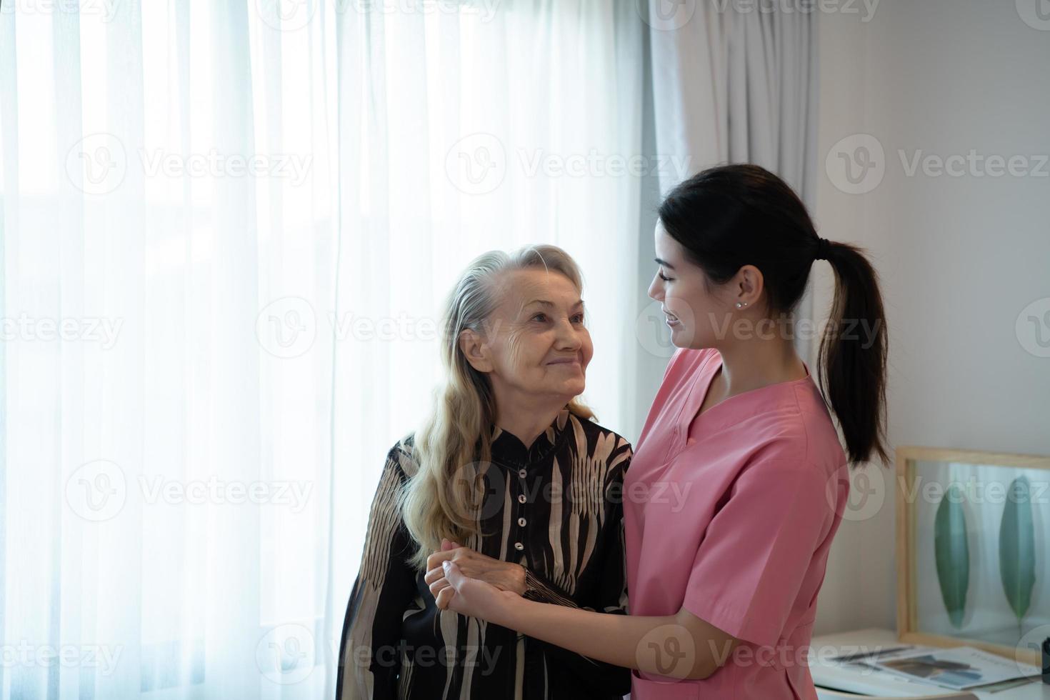 cuidador para un mayor mujer semanal chequeos a el del paciente residencia. Listo a dar médico Consejo y hablar acerca de varios cuentos, intercambiar cada otro felizmente. foto