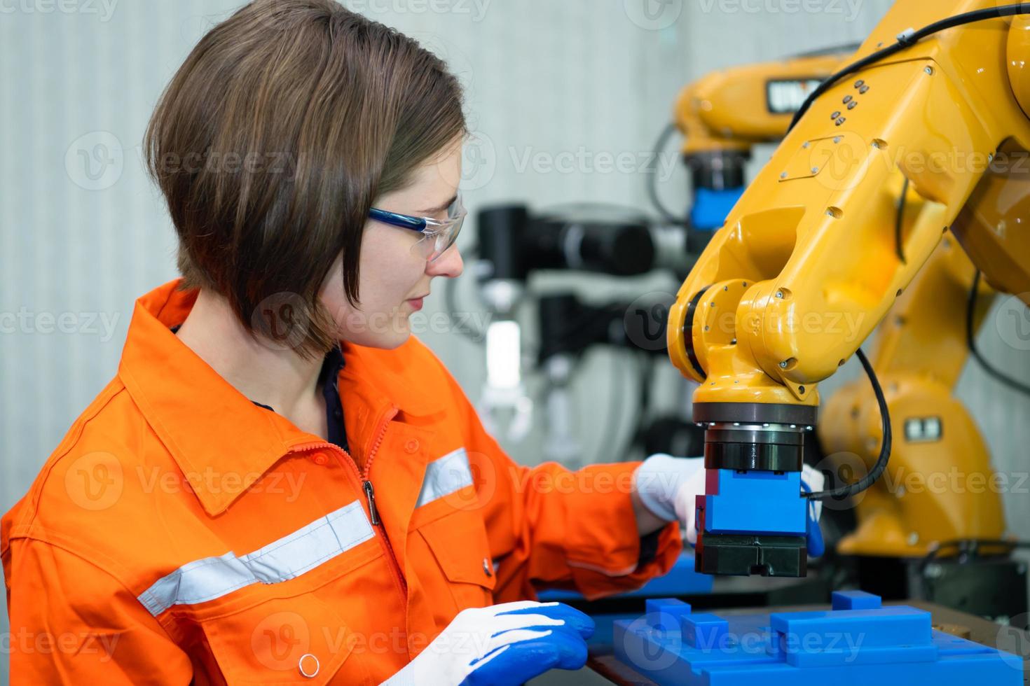 In an electronic parts facility, Female engineers In the plant, inspecting and testing robotic hands used in the production of electronic components. photo