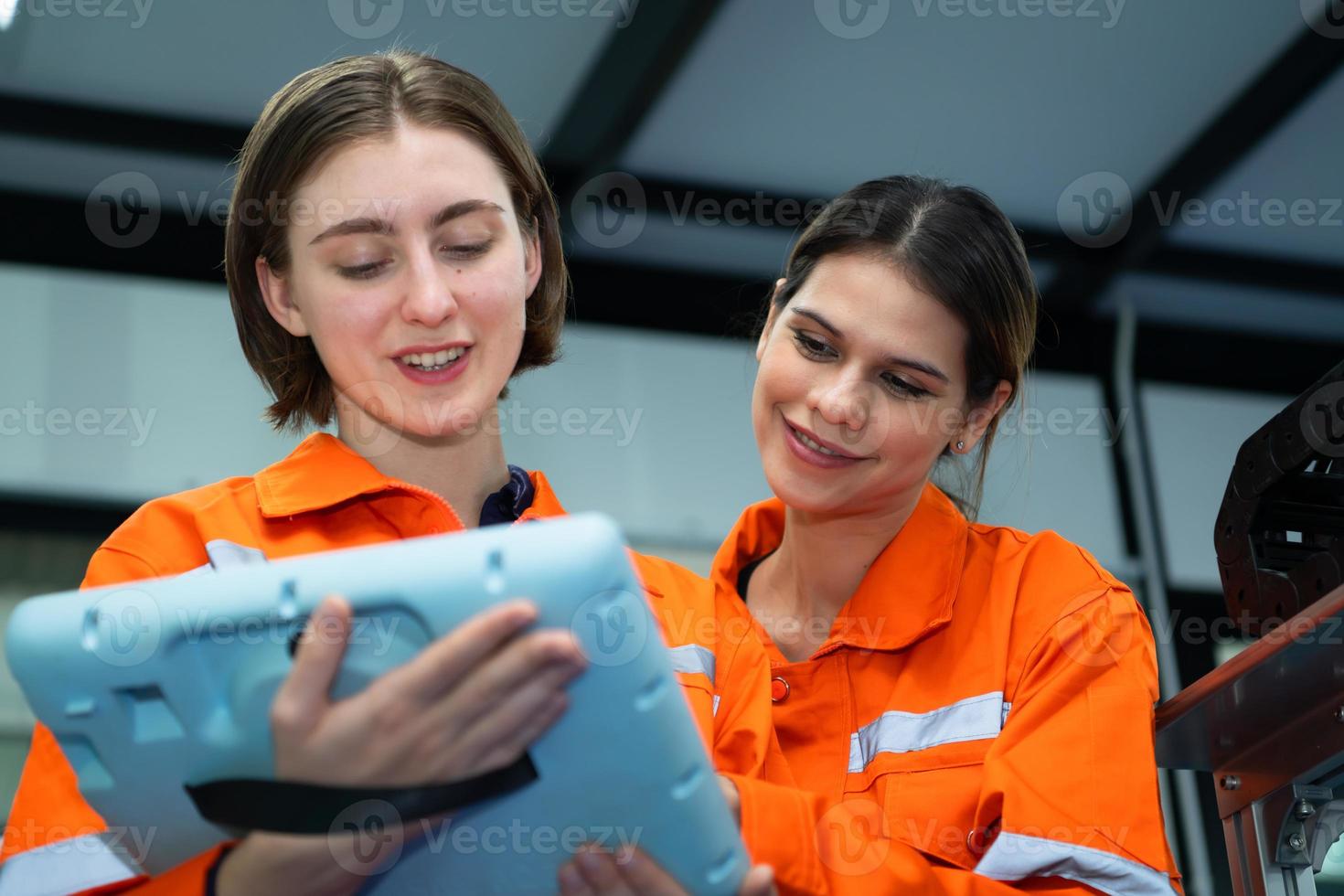 Both of woman in an electronic parts factory Using a production line controller and are recommending colleagues to use this tool. photo