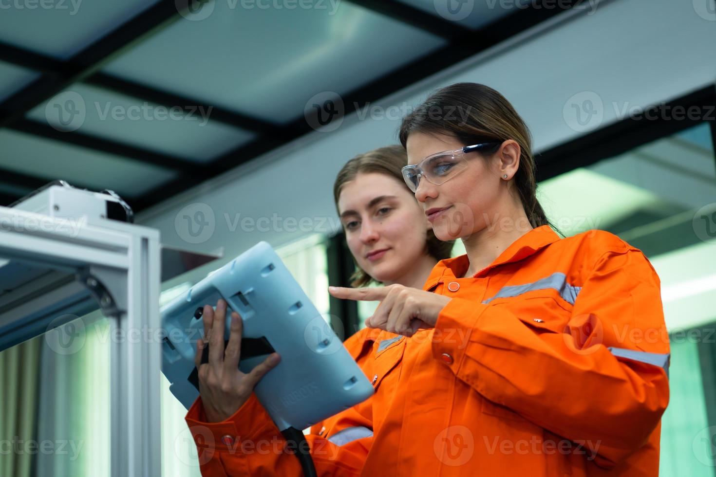 Both of woman in an electronic parts factory Using a production line controller and are recommending colleagues to use this tool. photo
