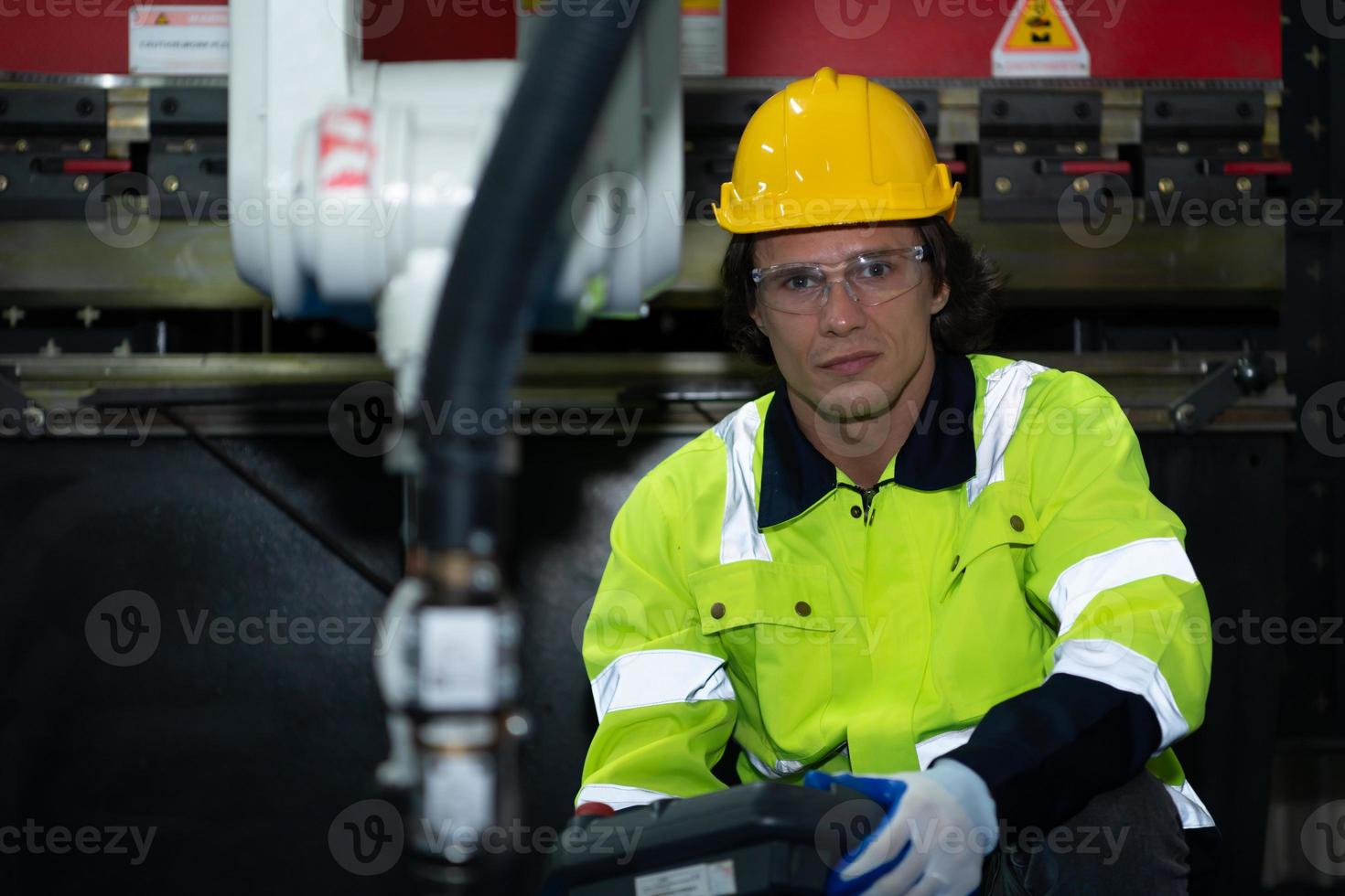 A big welding robot is being inspected and controlled by a robotics engineer. After the machine has been used for the specified amount of time. photo