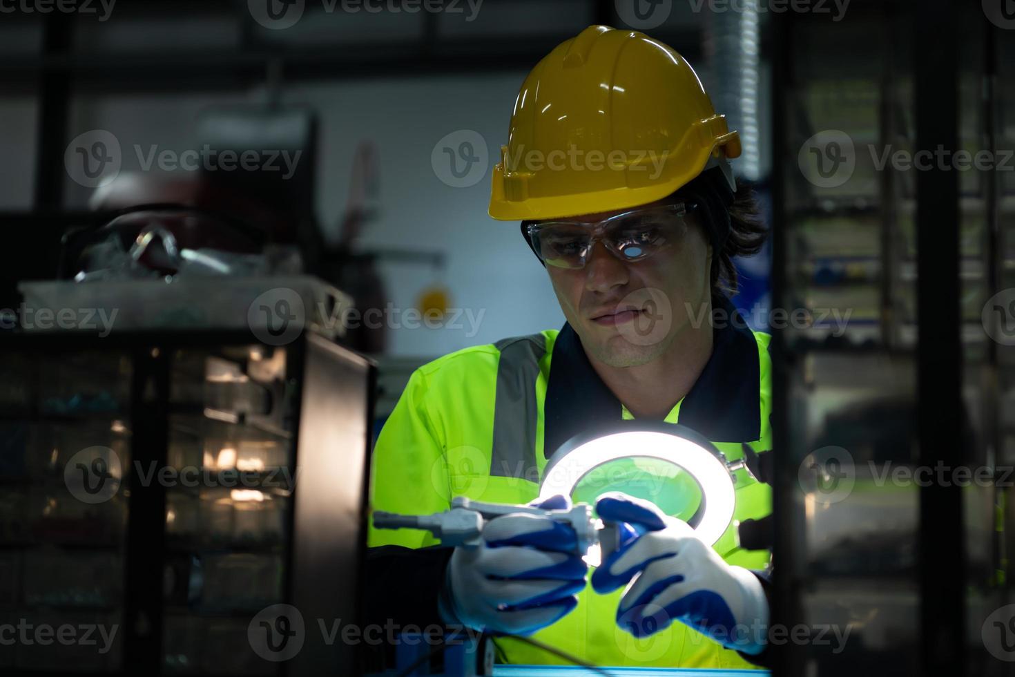The technician must use bright lights and a magnifying glass to check the detail of the workpiece. the 3D printer's printout. photo