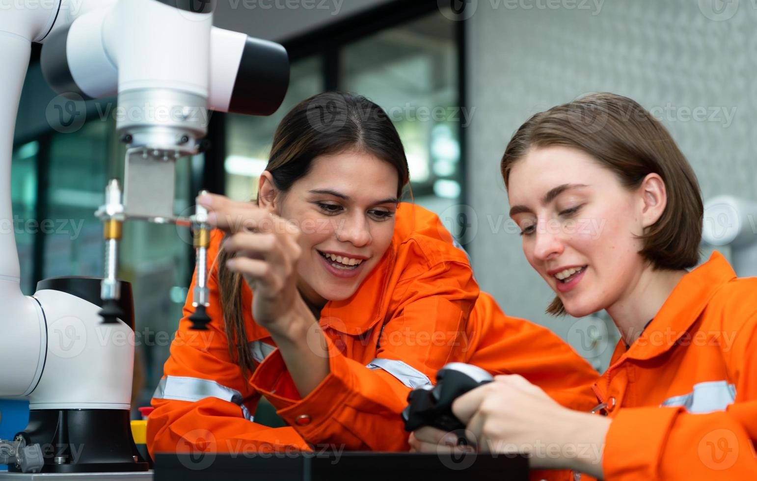 In an electronic parts facility, two female engineers In the plant, inspecting and testing robotic hands used in the production of electronic components. photo