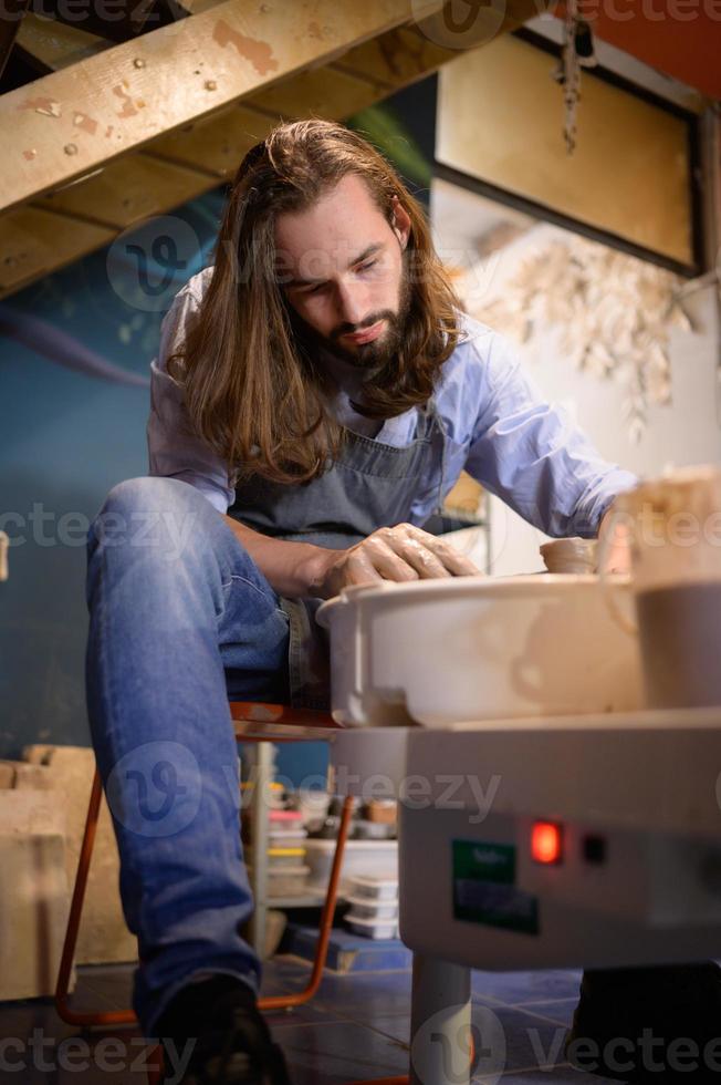 Pottery artist, Young making a piece of clay molding calmly and meticulously In order to produce the most attractive work possible, photo