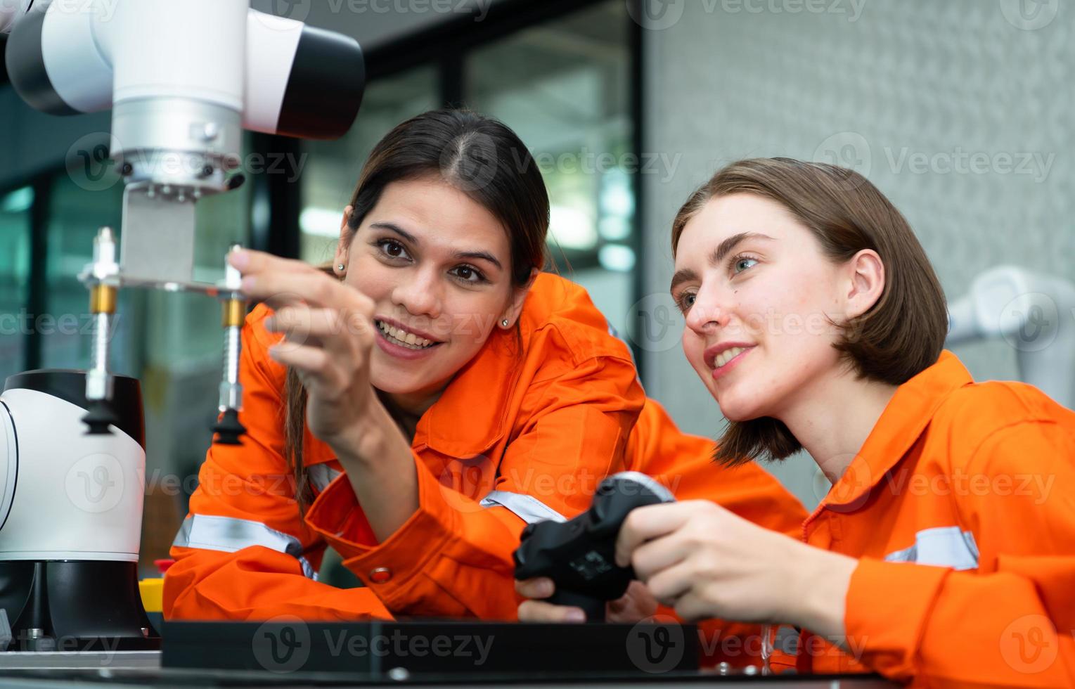 In an electronic parts facility, two female engineers In the plant, inspecting and testing robotic hands used in the production of electronic components. photo