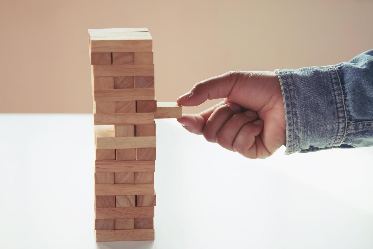 cerca arriba de mano empresario jugando bloquear madera foto