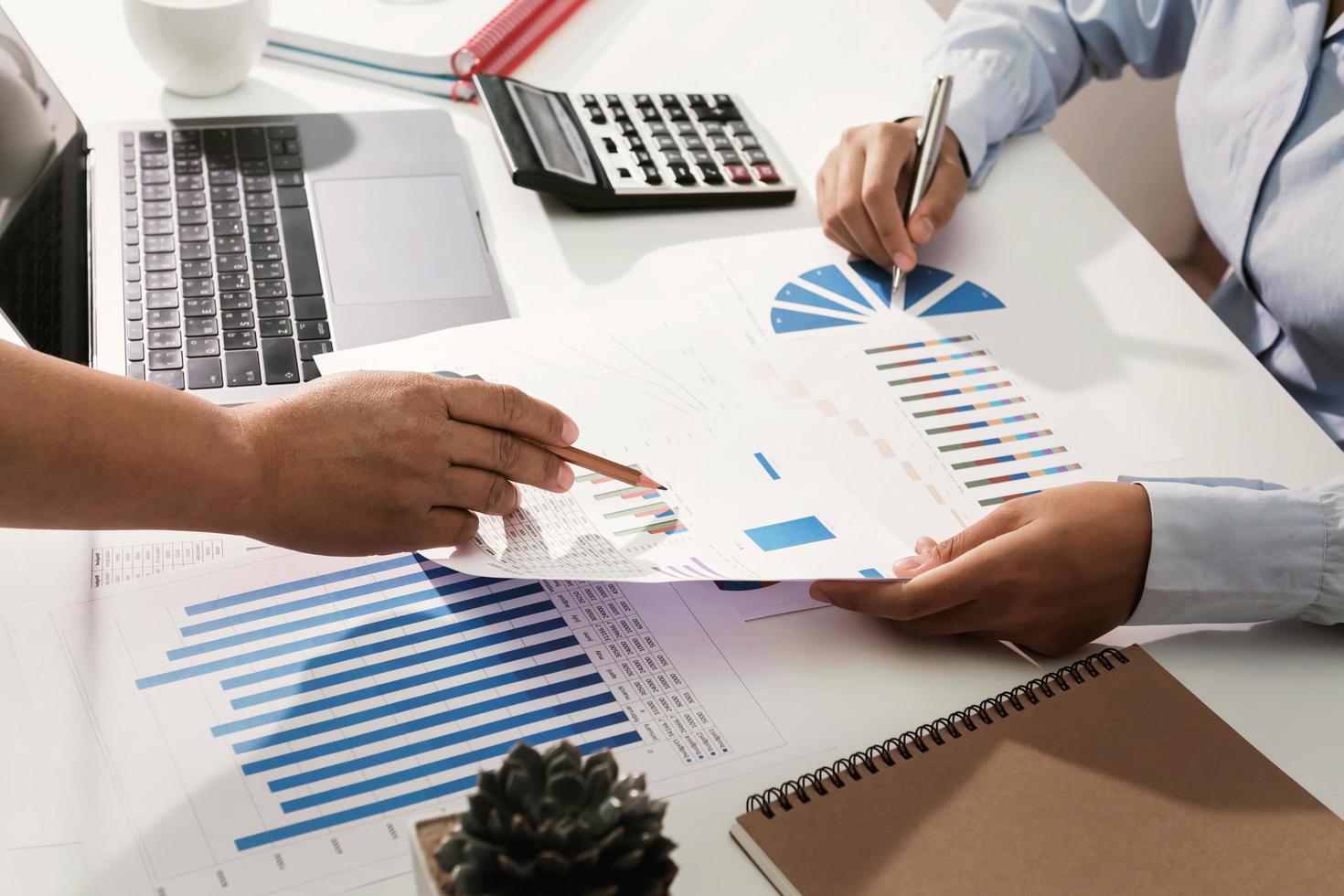 business team working on desk checking analyzing finance accounting in office photo
