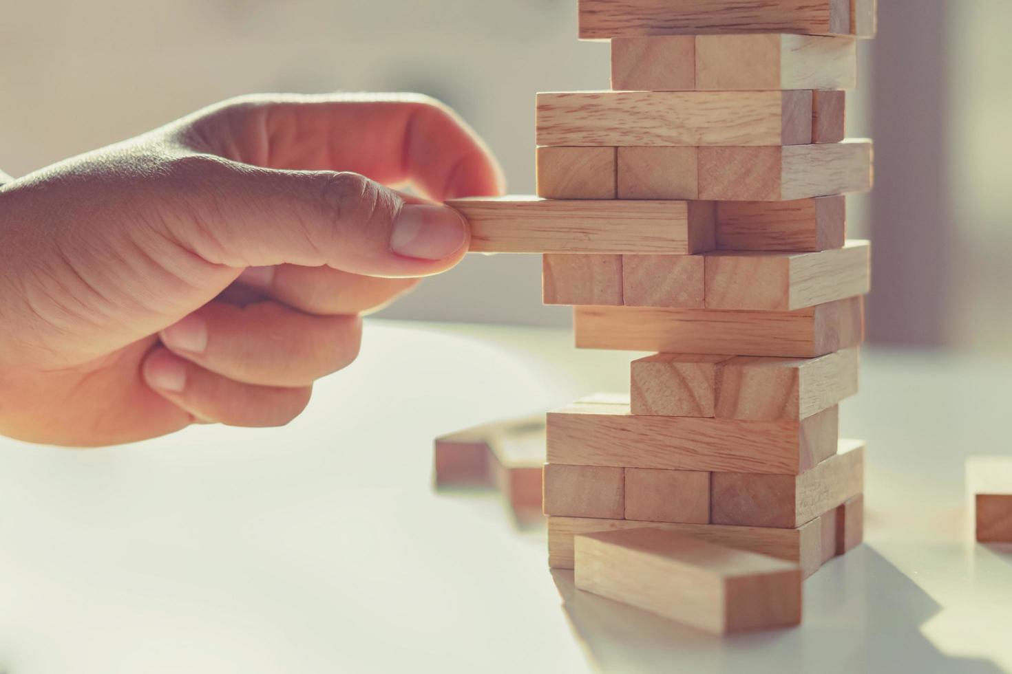 close up of hand playing block wood with sunshine background photo