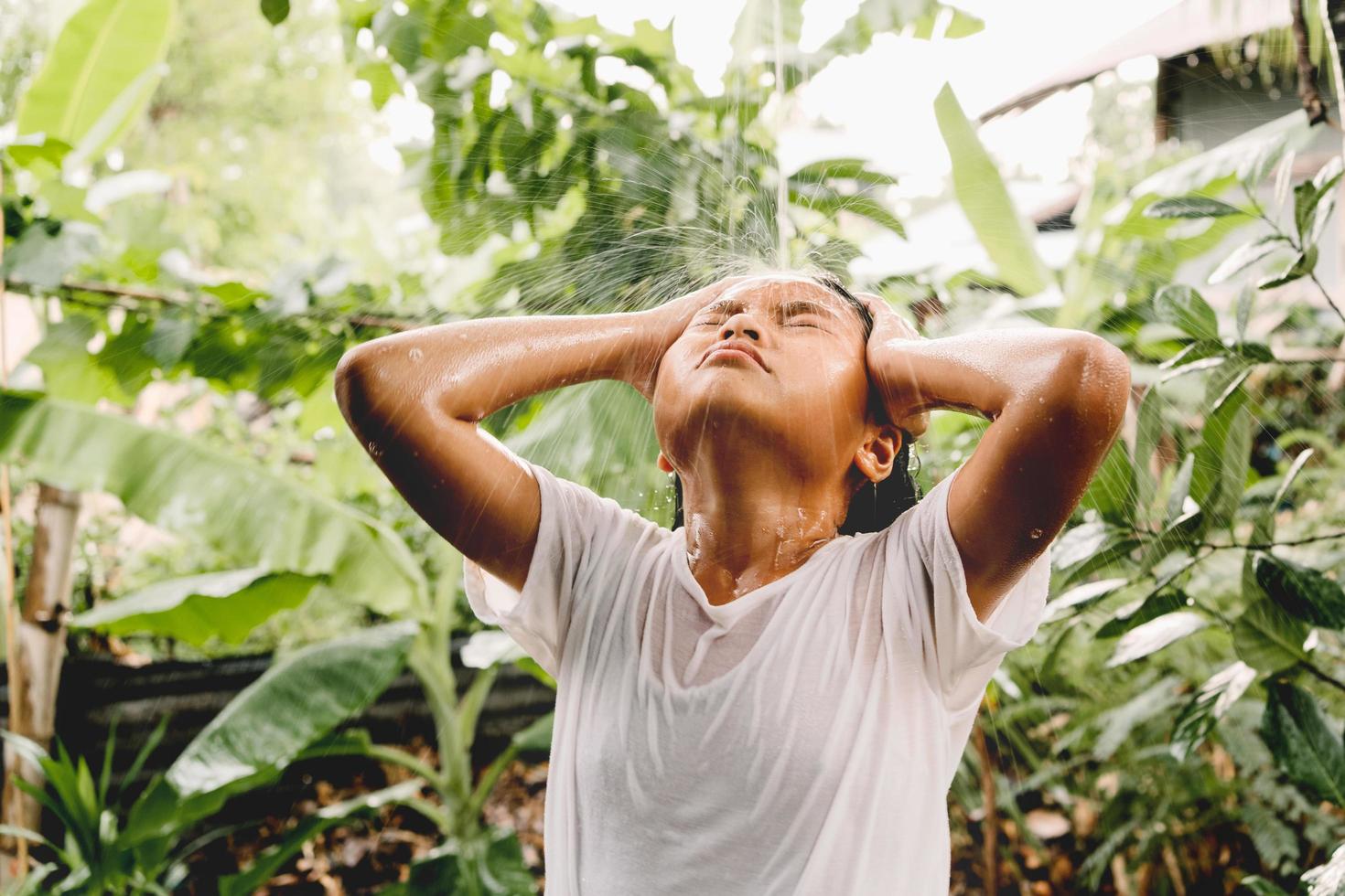 children take bath with summer rain on green nature background photo