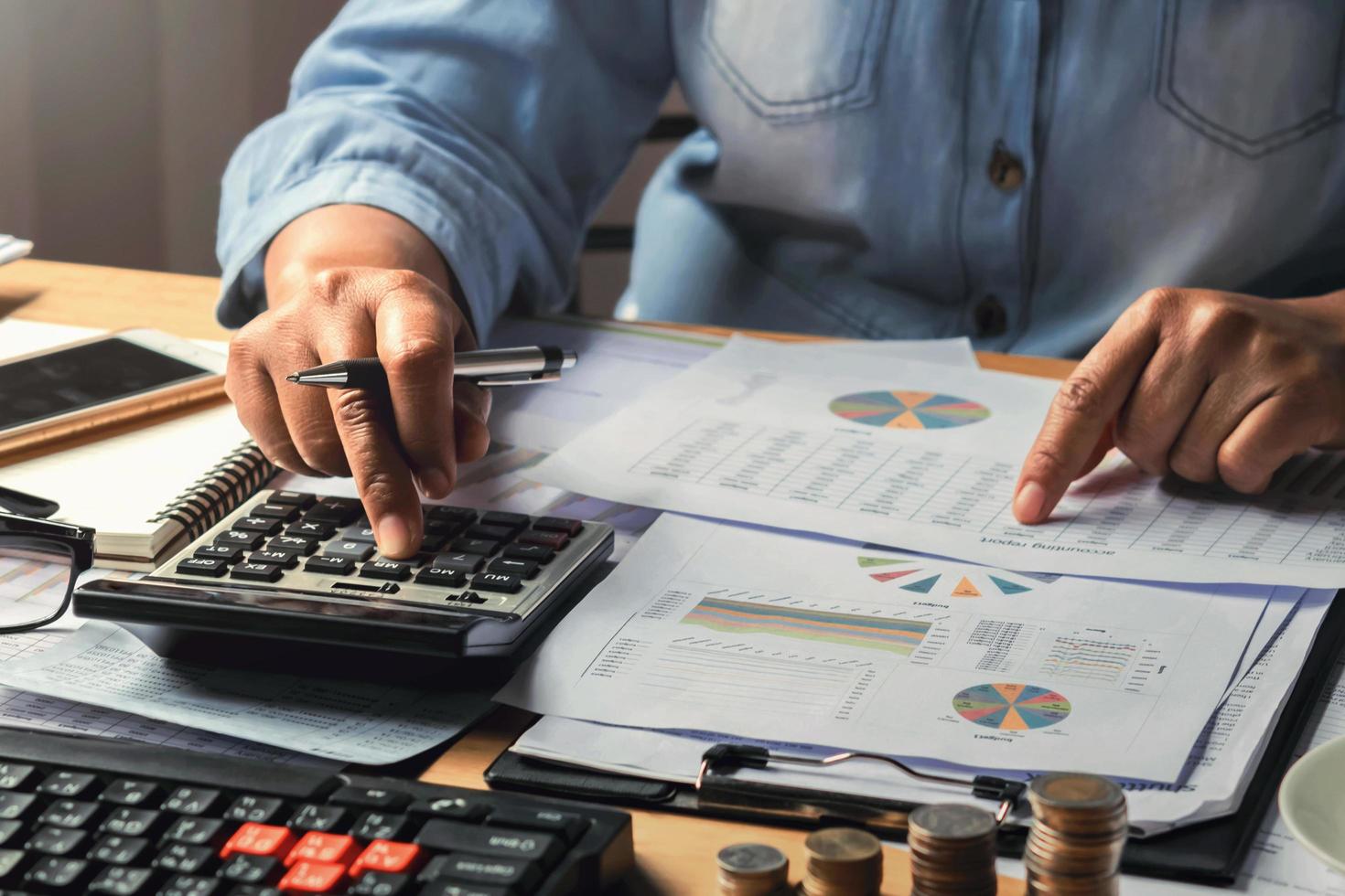 accounting concept. businesswoman working using calculator with money stack in office photo