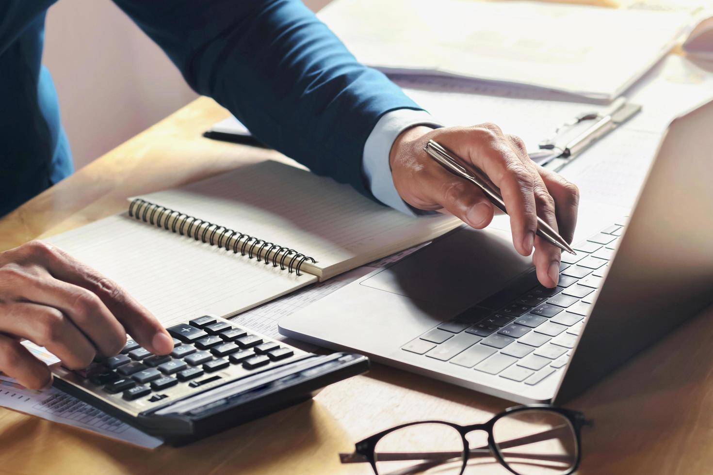businessman working on desk with using calculator and computer in office. concept accounting finance photo
