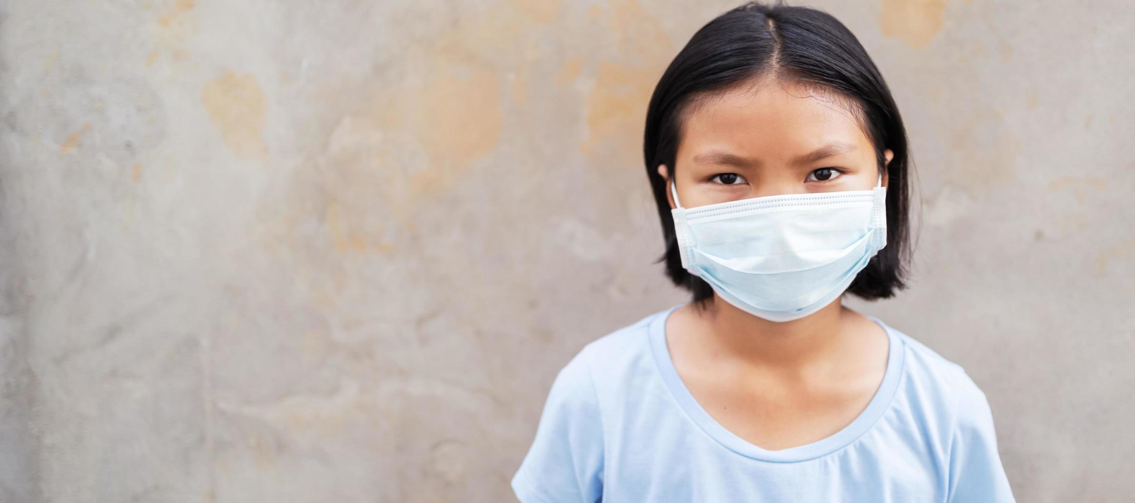 children girl wearing face mask protect of air pollution and virus epidemic of  covid 19 photo