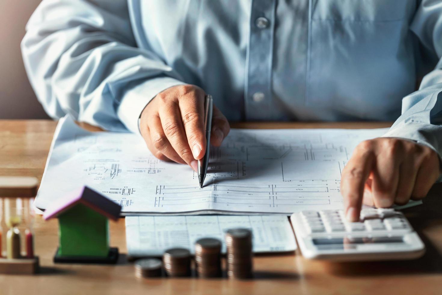 businessman working on desk office with using a calculator to calculate finance accounting concept photo