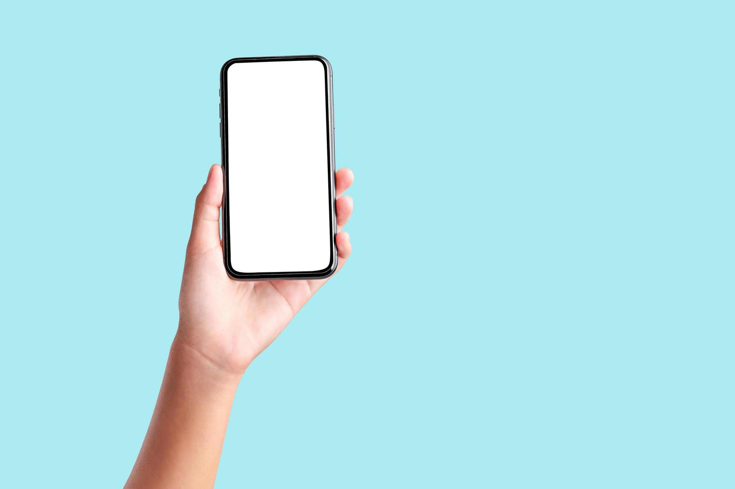 hand holding blank screen mobile phone isolate on blue background photo
