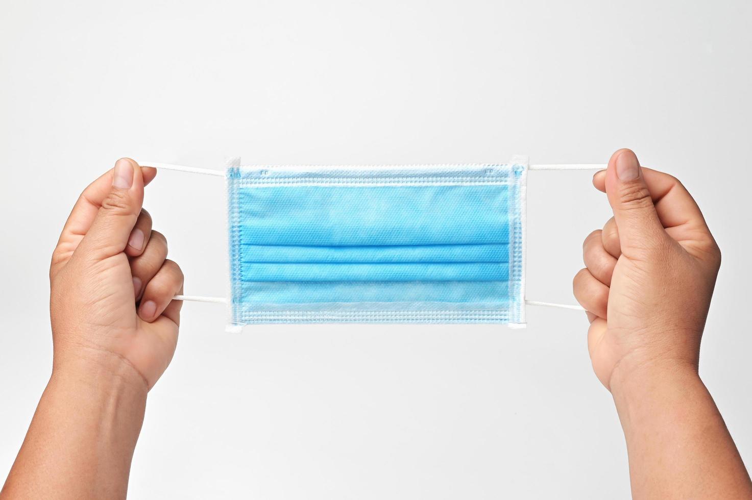 hand holding antiviral medical mask protection against coronavirus covid 19. isolate on white background photo