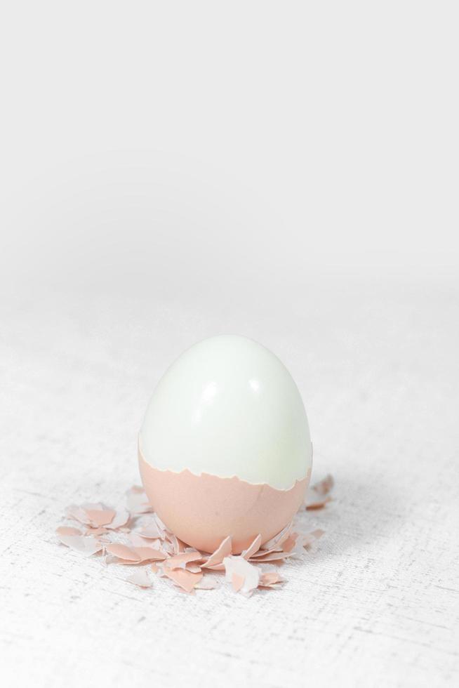 The cracked shell of a cracked egg sits nearby photo