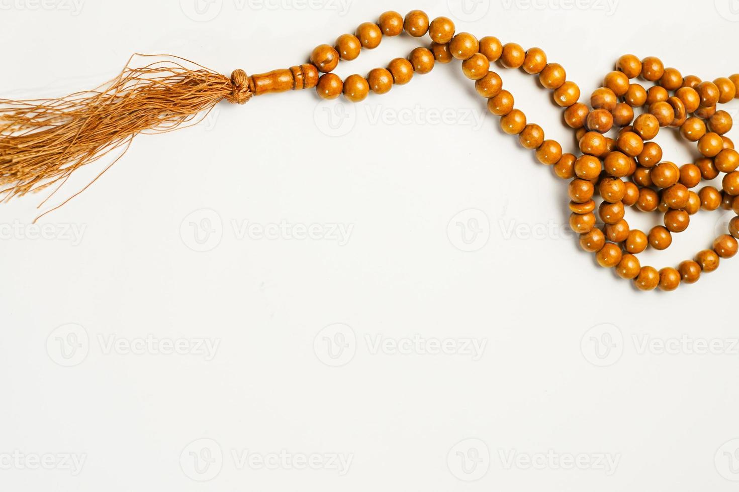 The Holy Al Quran with written arabic calligraphy meaning of Al Quran and rosary beads or tasbih on white background, isolated with copy space. photo