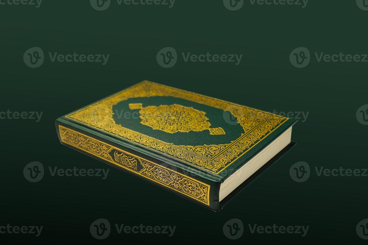 The Holy Al Quran with written arabic calligraphy meaning of Al Quran and rosary beads or tasbih on dark green black background with copy space. photo