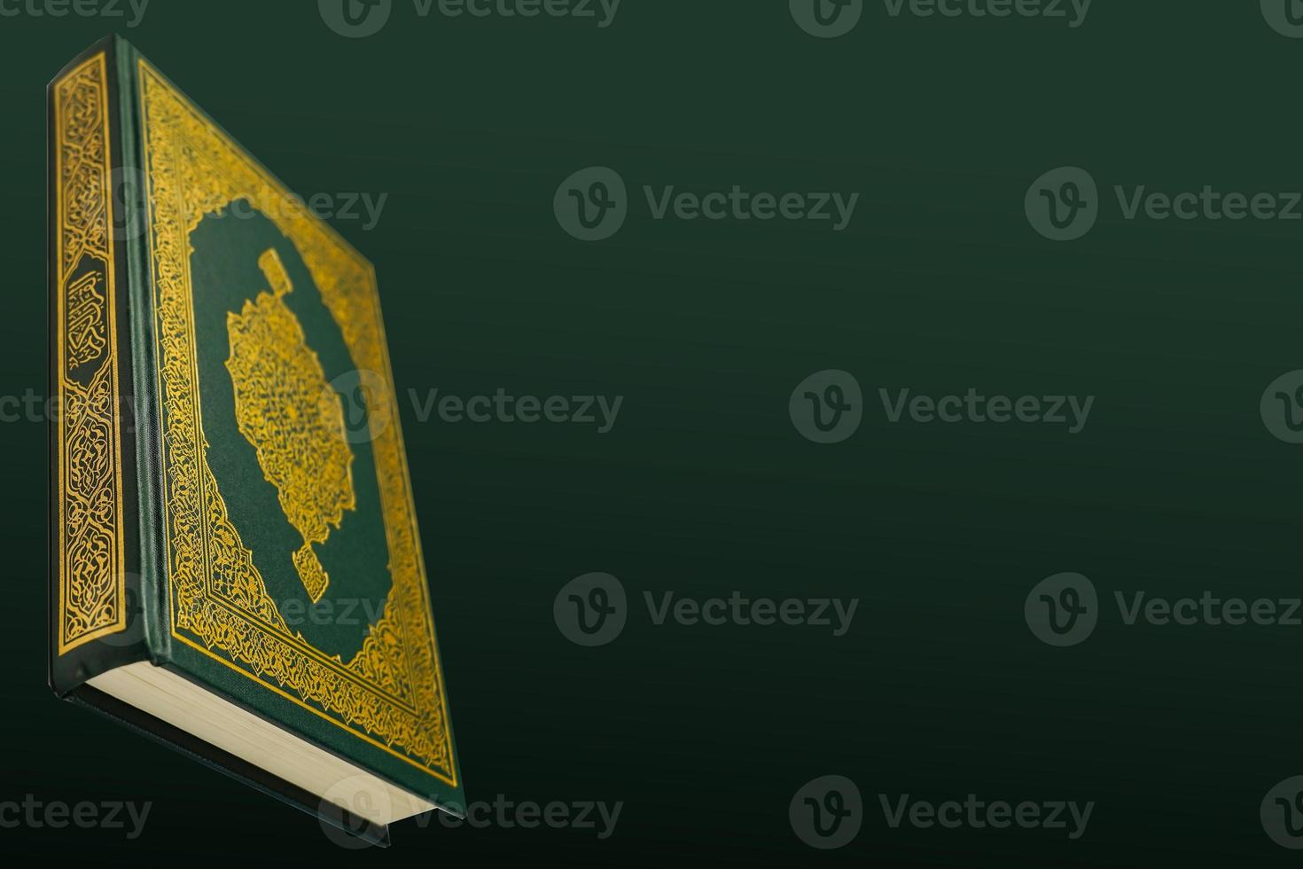 The Holy Al Quran with written arabic calligraphy meaning of Al Quran and rosary beads or tasbih on dark green black background with copy space. photo