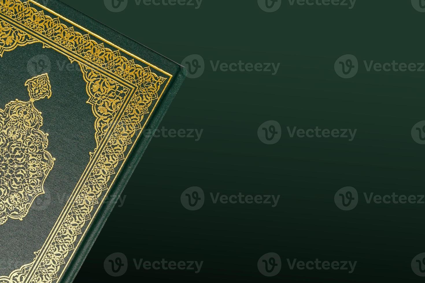 The Holy Al Quran with written arabic calligraphy meaning of Al Quran and rosary beads or tasbih on dark green black background with copy space. photo