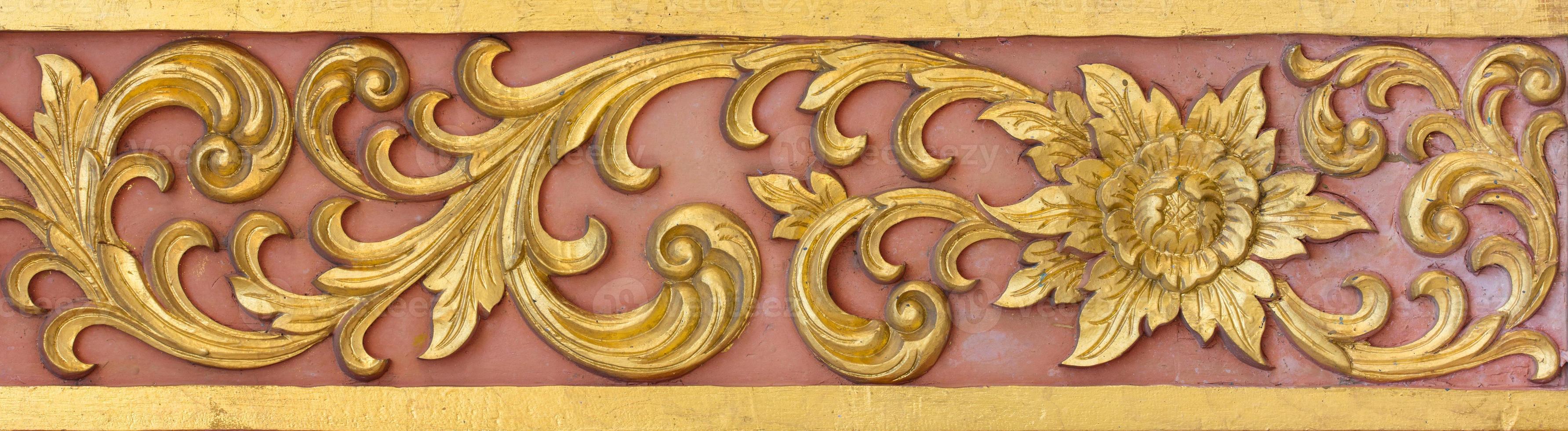Pattern of gold flower carved on stucco design of native wall, Thai style in temple photo