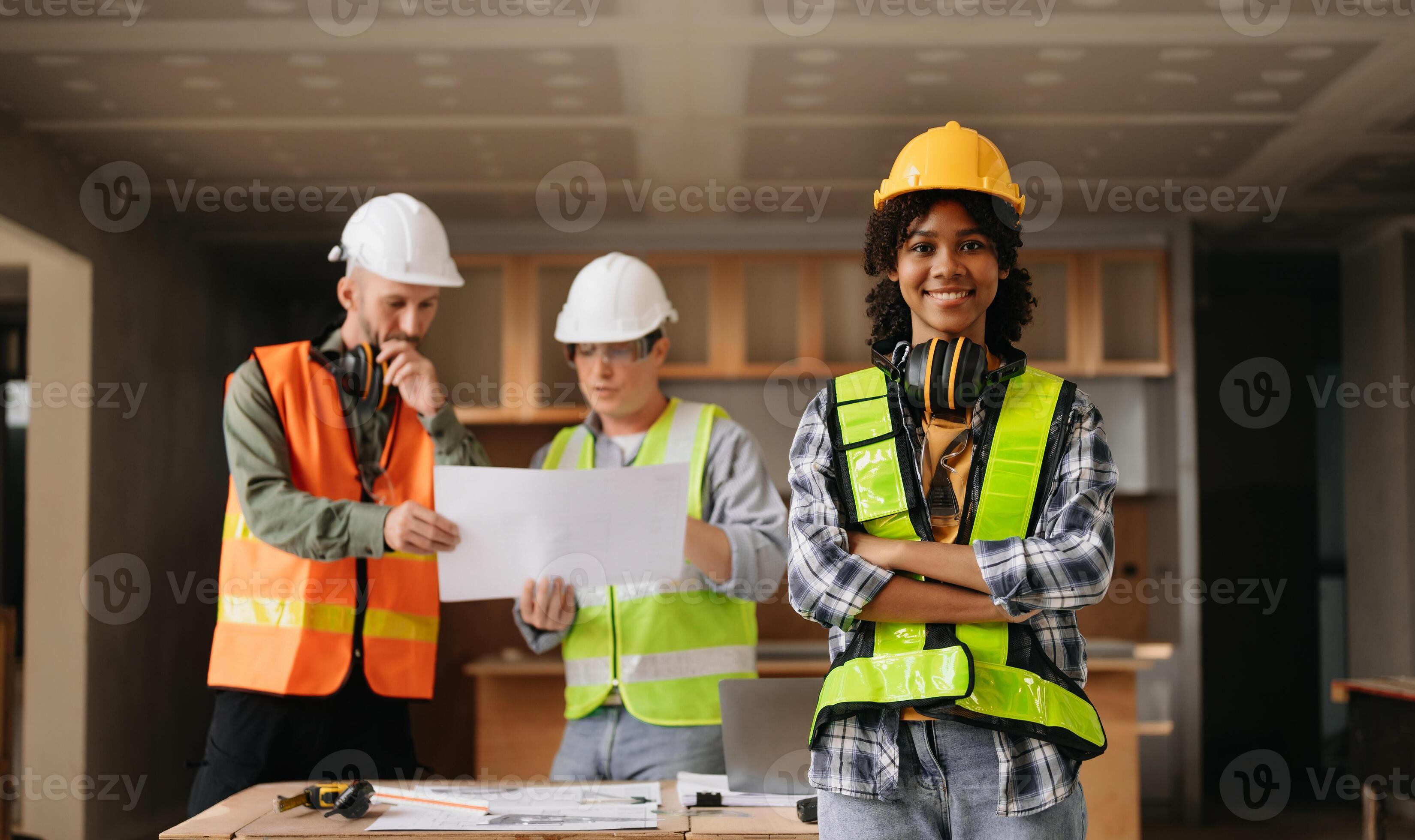 Contractor and architect looking at plan, tablet, laptop and talking