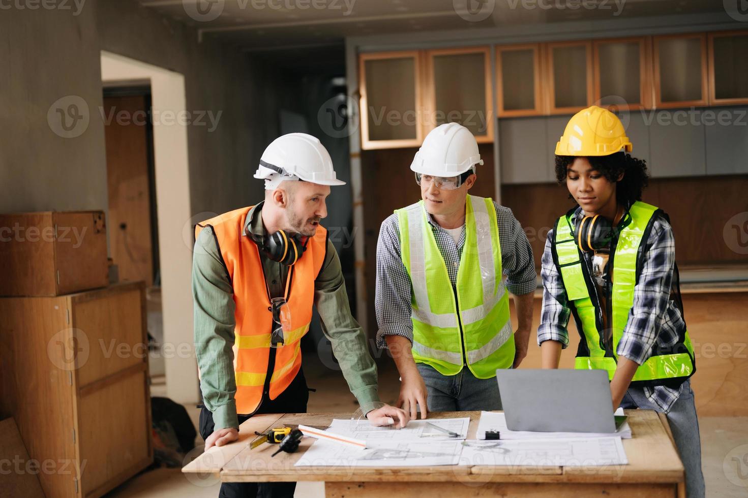 Architect caucasian man and woman working with colleagues mixed race in the construction site. Architecture engineering on big project. Building in construction process interior. photo