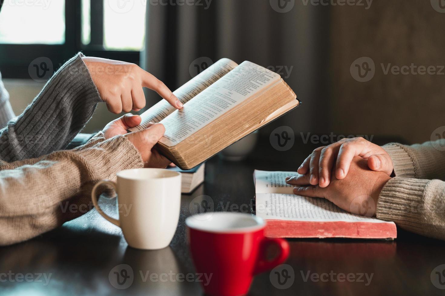 Small group of asian people praying worship believe. Teams of friends worship together before studying Holy bible. family praying together in church. Small group learning with prayer concept. photo