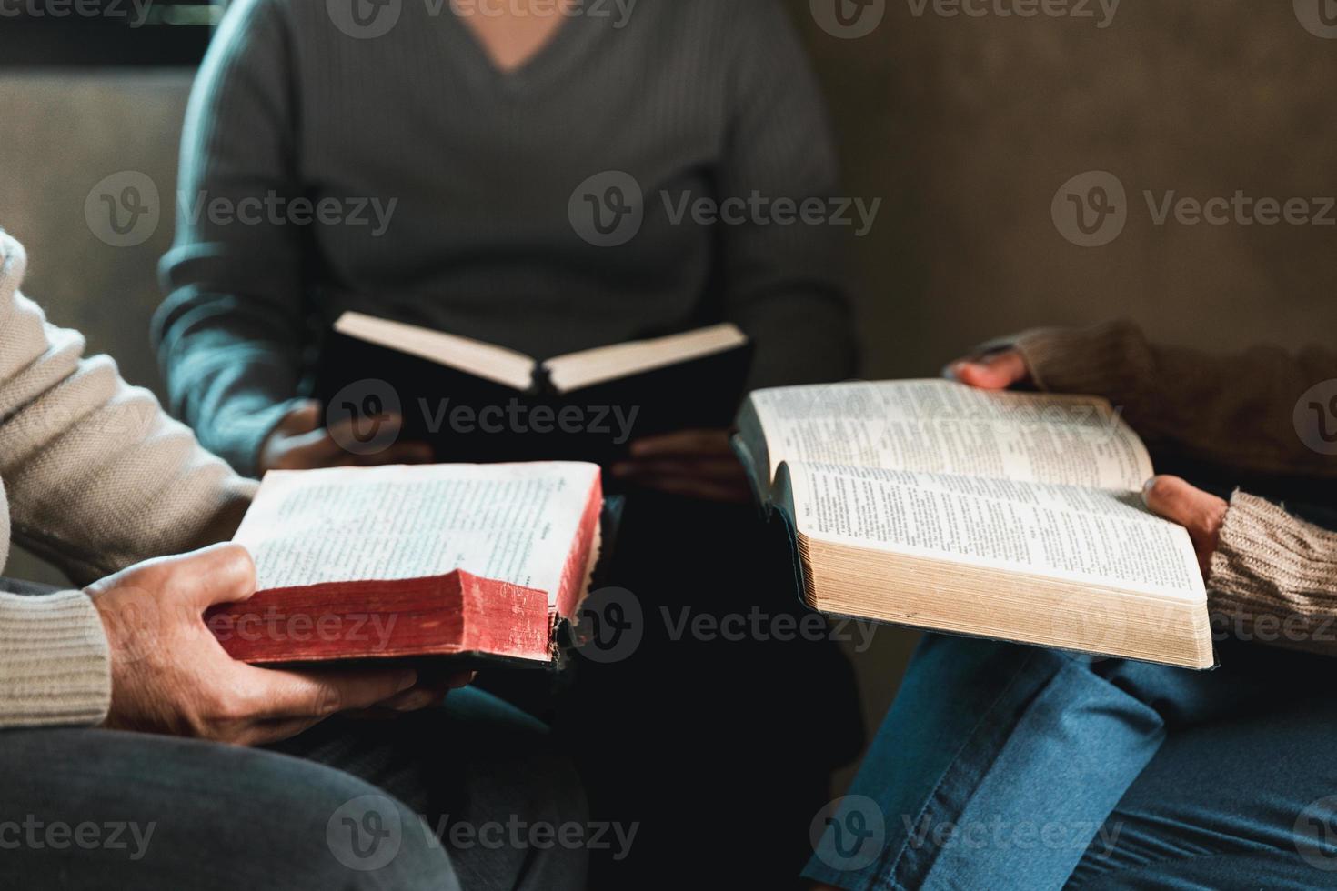 Small group of asian people praying worship believe. Teams of friends worship together before studying Holy bible. family praying together in church. Small group learning with prayer concept. photo