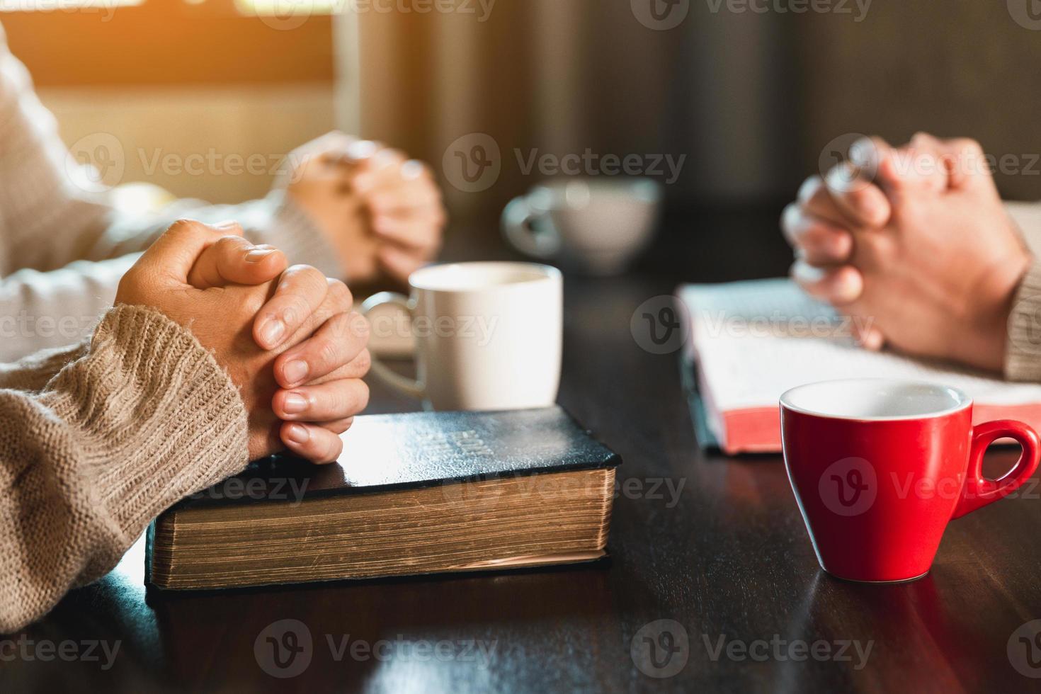 Small group of asian people praying worship believe. Teams of friends worship together before studying Holy bible. family praying together in church. Small group learning with prayer concept. photo