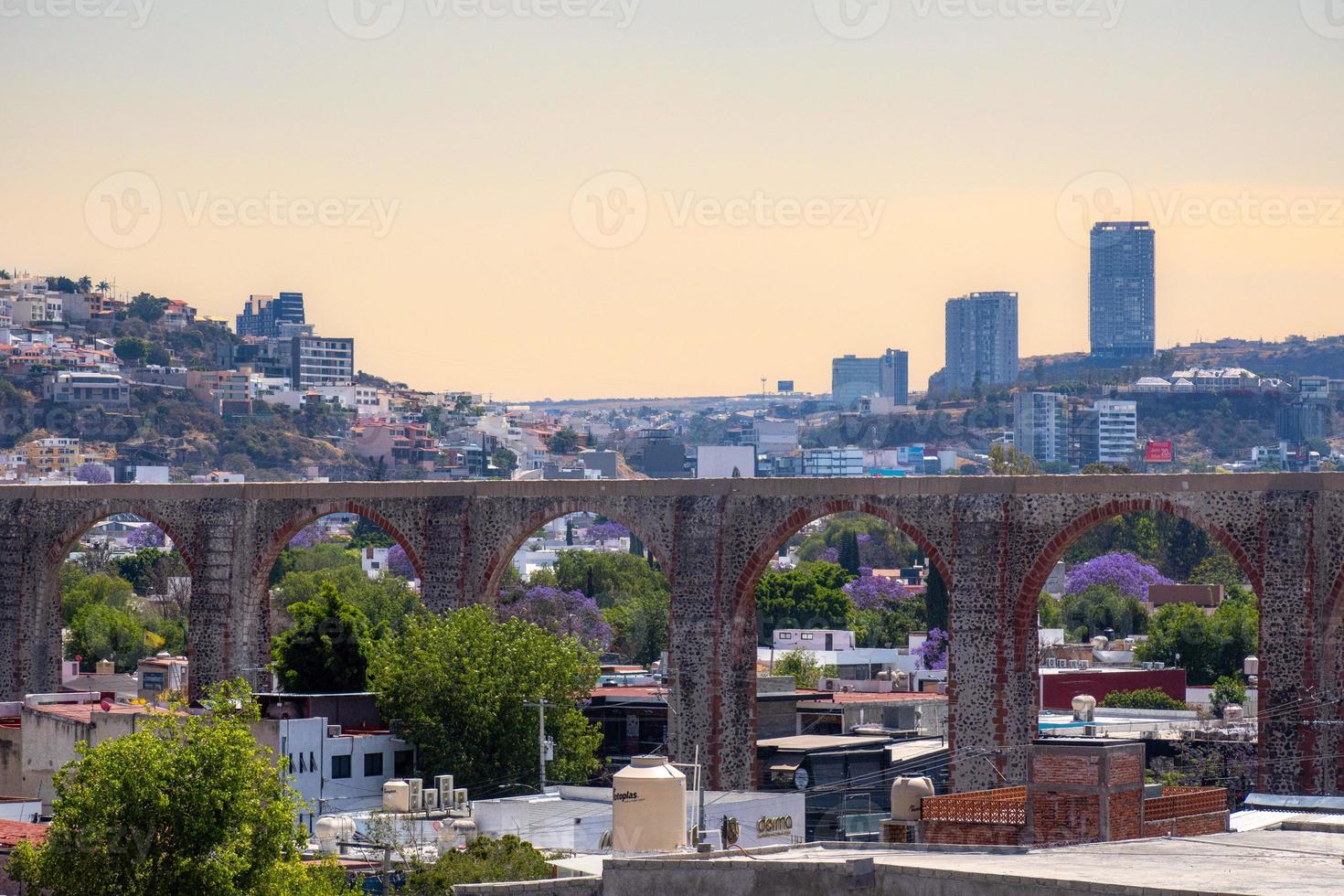 View of the city of Queretaro Mexico aqueduct with jacaranda tree photo