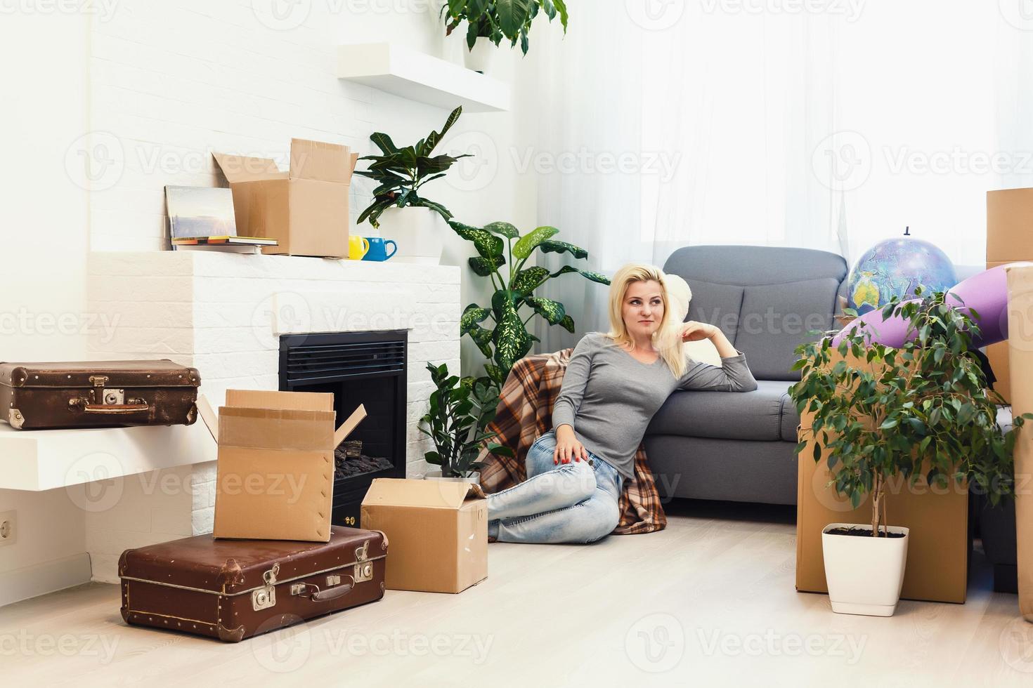 Happy young girl with boxes moves to new apartment photo