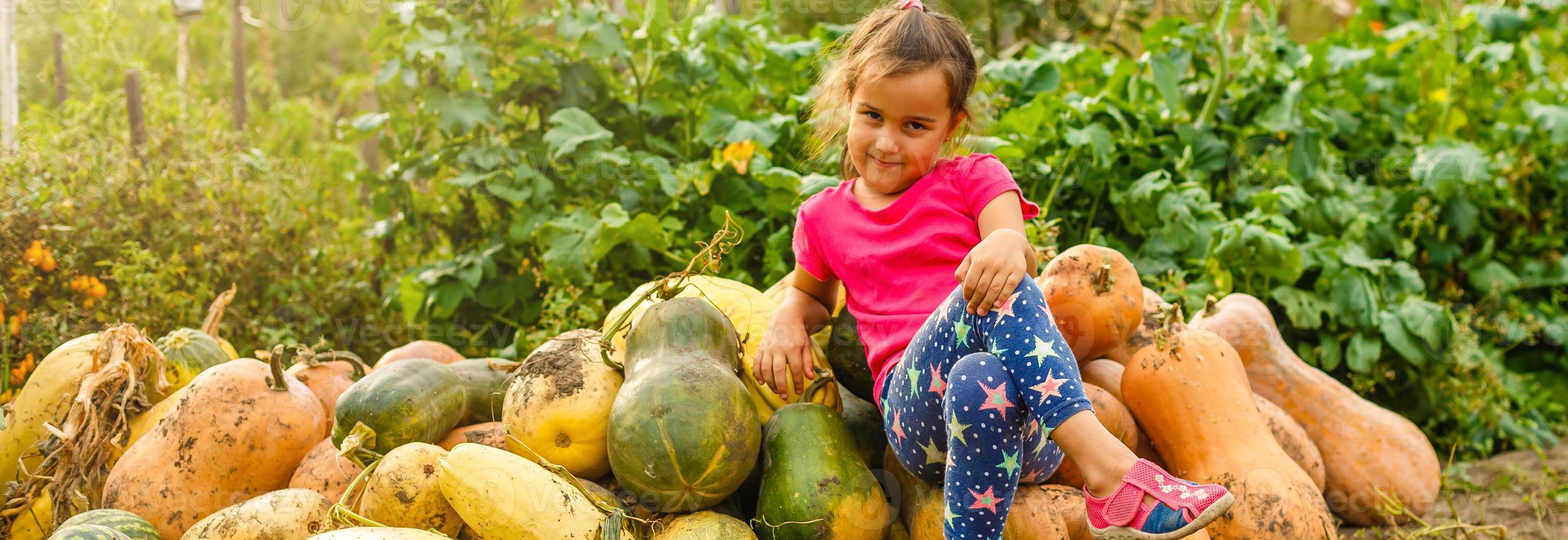 Little girl with pumpkin outdoor having fun in autumn park. photo