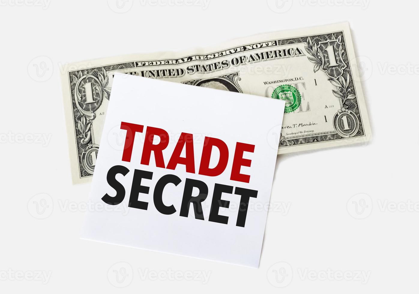 1 dollar bill and white notepad sheet on the white background. Text trade secret photo