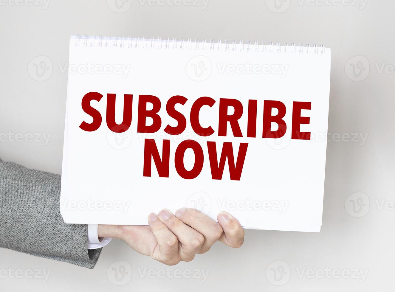 man's hand holding paper sheet with subscribe now words photo