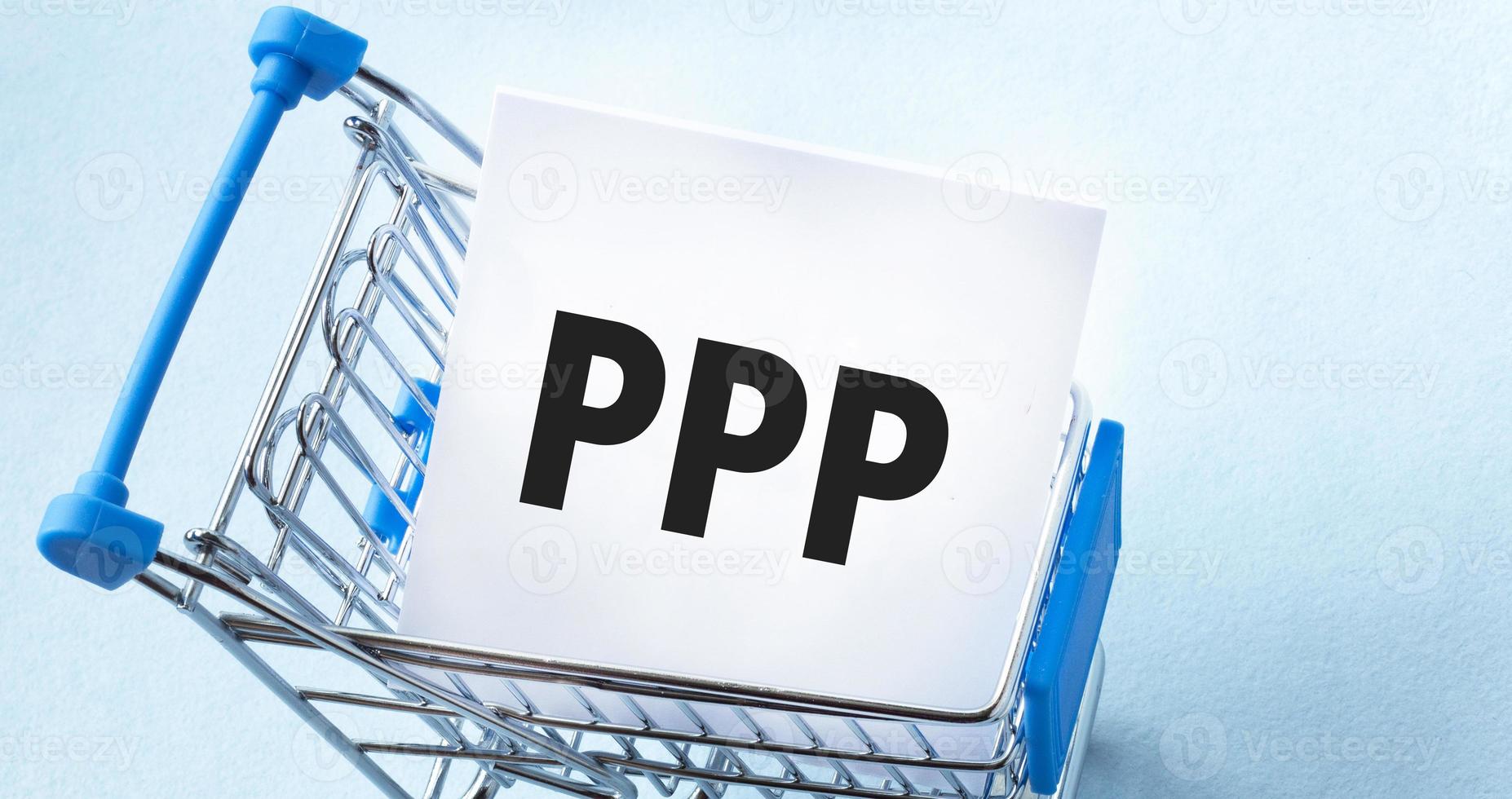 Shopping cart and text ppp loan on white paper note list. Shopping list concept on blue background. photo