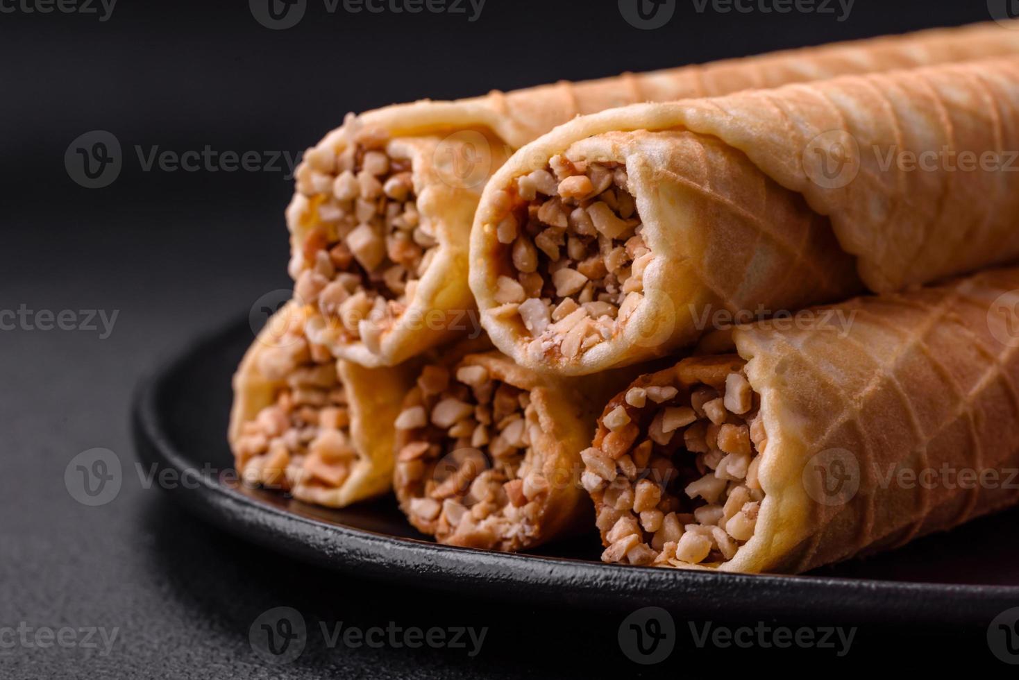 Delicious crispy wafer rolls with cream filling with nuts photo