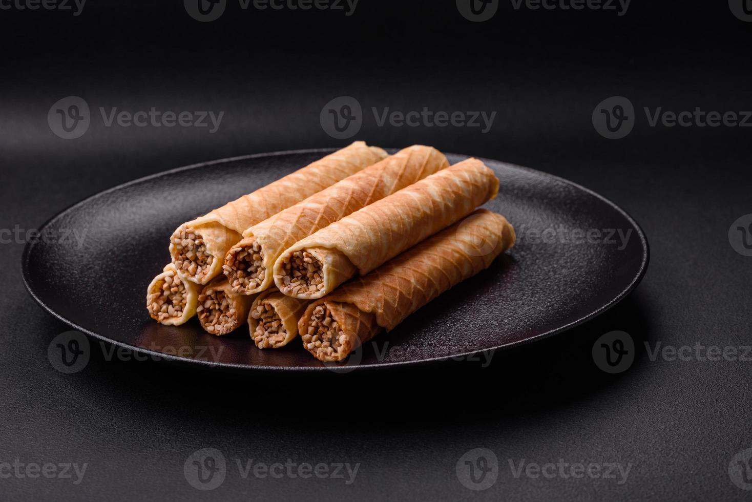 Delicious crispy wafer rolls with cream filling with nuts photo