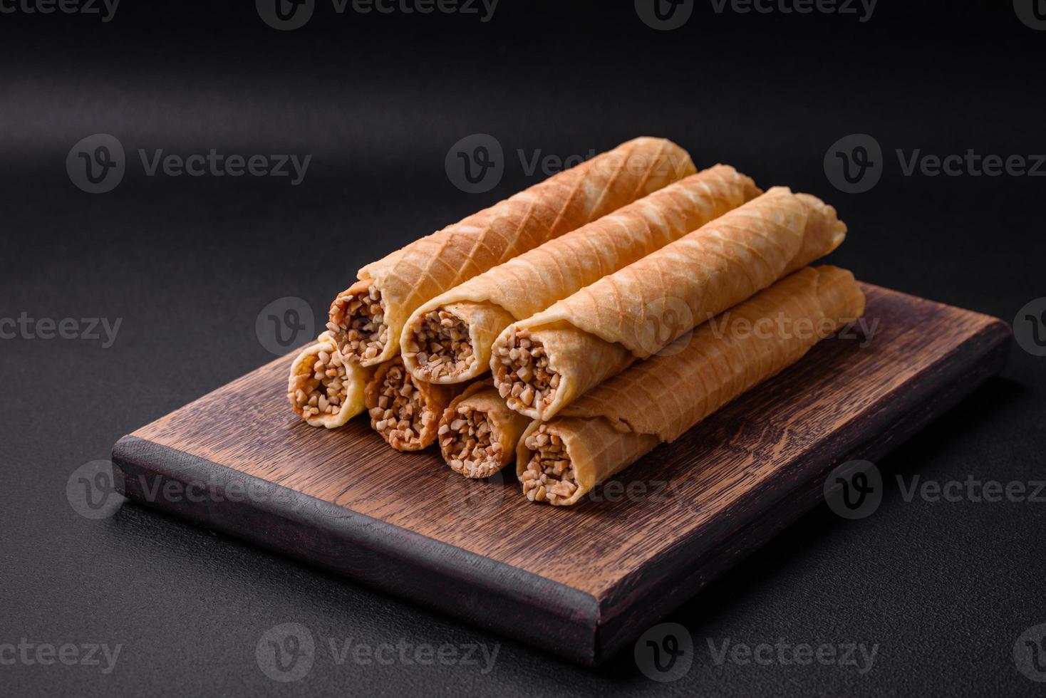 Delicious crispy wafer rolls with cream filling with nuts photo