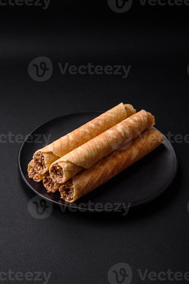 Delicious crispy wafer rolls with cream filling with nuts photo