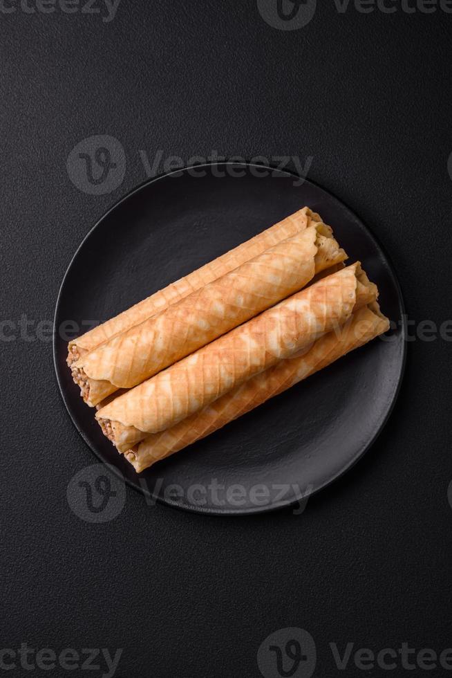 Delicious crispy wafer rolls with cream filling with nuts photo