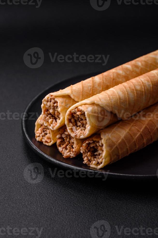 Delicious crispy wafer rolls with cream filling with nuts photo