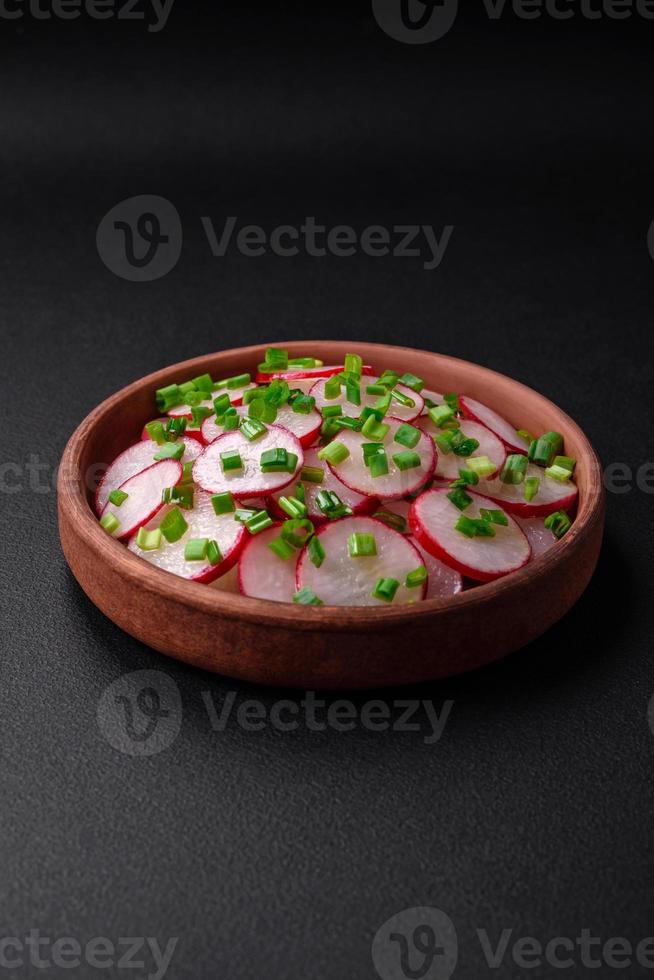 Delicious fresh salad of sliced radishes with green onions, salt and olive oil photo