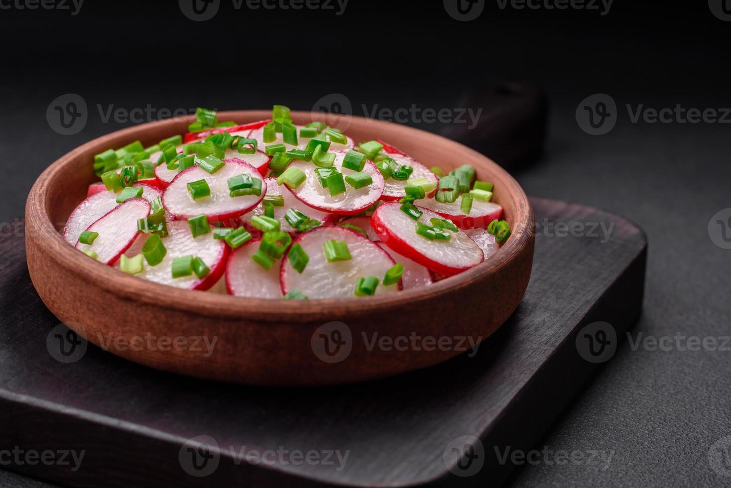 Delicious fresh salad of sliced radishes with green onions, salt and olive oil photo