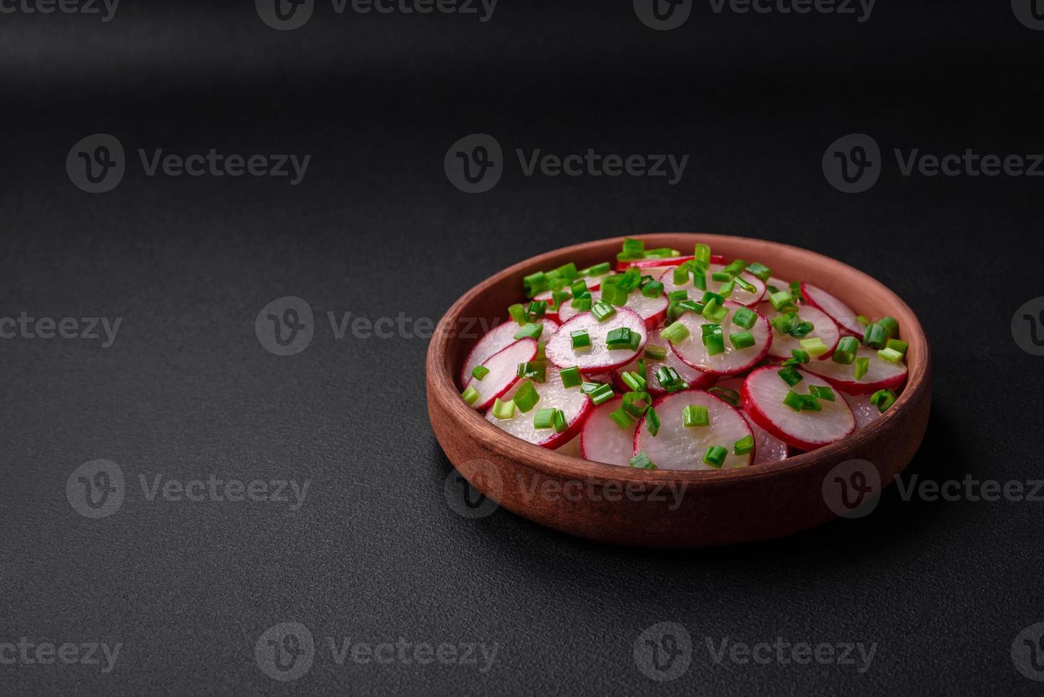 Delicious fresh salad of sliced radishes with green onions, salt and olive oil photo
