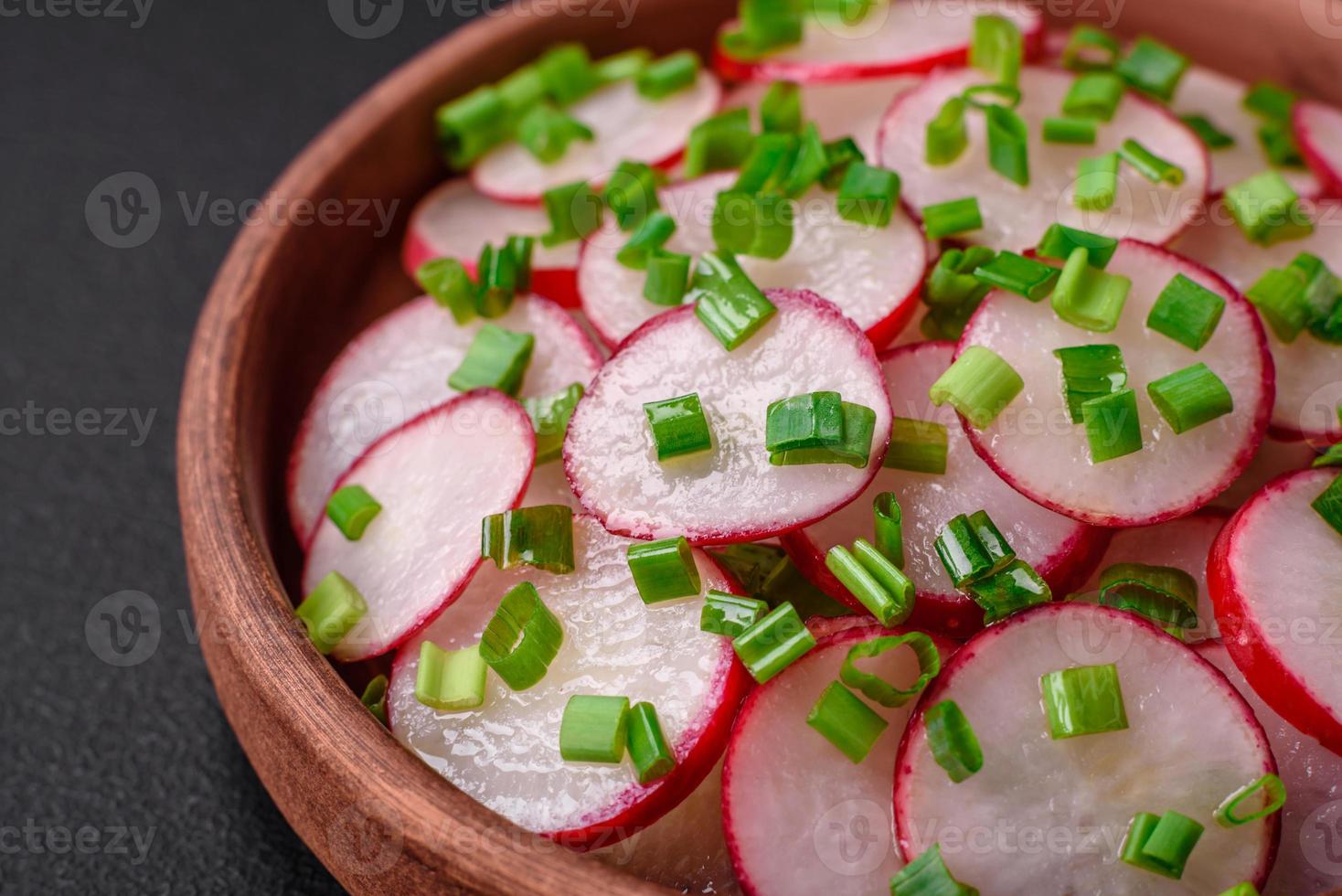 Delicious fresh salad of sliced radishes with green onions, salt and olive oil photo